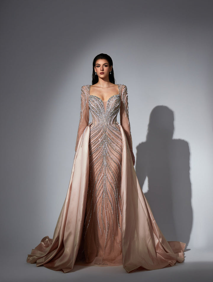 Delilah LD11475 Plunging Illusion Long Sleeve Beaded Corset Sheath Gown with Overskirt - Champagne front view